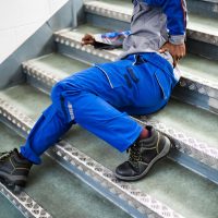 Worker Man Lying On Staircase After Slip And Fall Accident Worker Man Lying On Staircase After Slip And Fall Accident