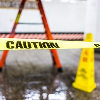 Caution tape sign in underground transit empty large platform in New York City NYC Subway Station in Grand Central, ladder, wet floor cone Caution tape sign in underground transit empty large platform in New York City NYC Subway Station in Grand Central, ladder, wet floor cone